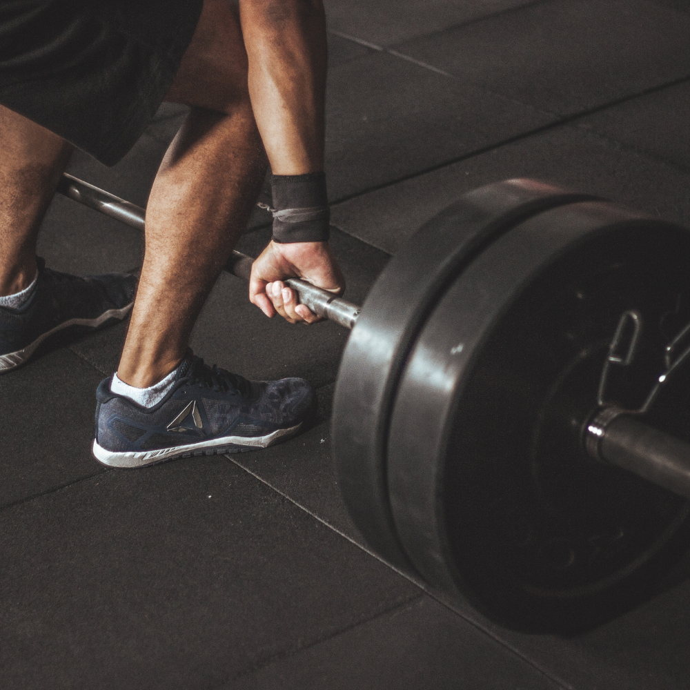 Person lifting a barbell in a gym setting